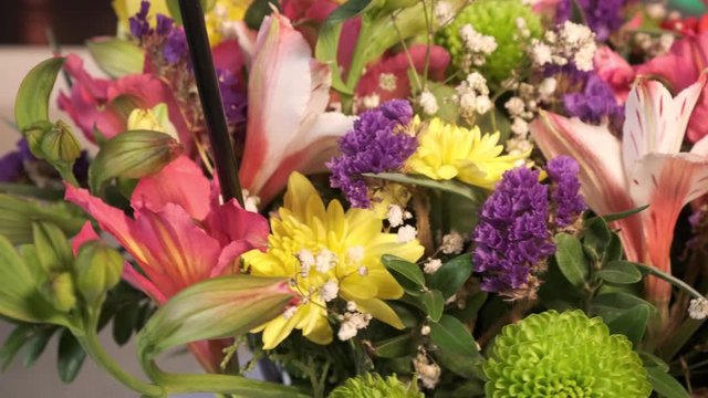 Rotating beautiful bright bouquet of colorful Alstroemeria, limonium, rose, tulip flowers. A perfect gift for a woman.