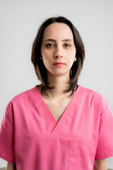 Young woman medical professional nurse or doctor dressed with pink hospital clothes