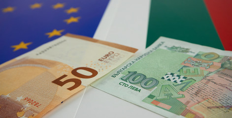 Bulgarian and European Union banknotes in front of EU and Bulgarian flag