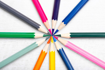 Fototapeta premium Flat lay composition with color pencils on light wooden background. Teamwork concept. Top view.