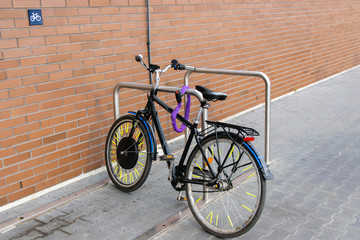 Fototapeta na wymiar Bike parked in a special parking lot near a brick wall.