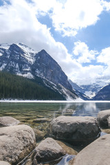 Fototapeta premium Mount fairview, partly frozen lake, rocks in foreground. Lake Louise Banff National Park, Alberta Canada