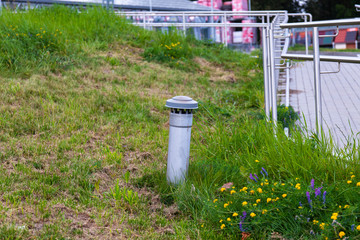 A small ventilation shaft overlooking the lawn near the footpath.