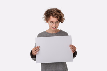 Smiling young woman with eyeglass holding empty blank paper board with copy space for text.