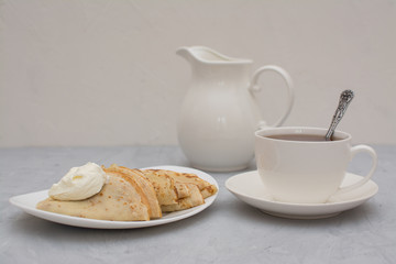 Homemade, thin, Russian pancakes with sour cream for breakfast.