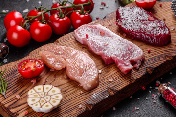 Fresh juicy steak of beef, pork and chicken with vegetables ready to cook