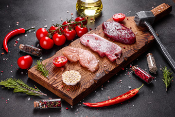 Fresh juicy steak of beef, pork and chicken with vegetables ready to cook