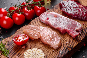 Fresh juicy steak of beef, pork and chicken with vegetables ready to cook