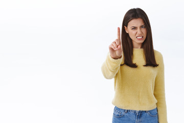 Displeased skeptical and disappointed young female customer shaking finger scolding for awful...