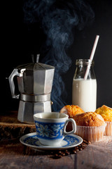 cup of steaming coffee and Italian coffee maker