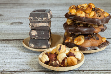 Stacked hazelnut and chocolate chip cookies and stacked chocolate pieces