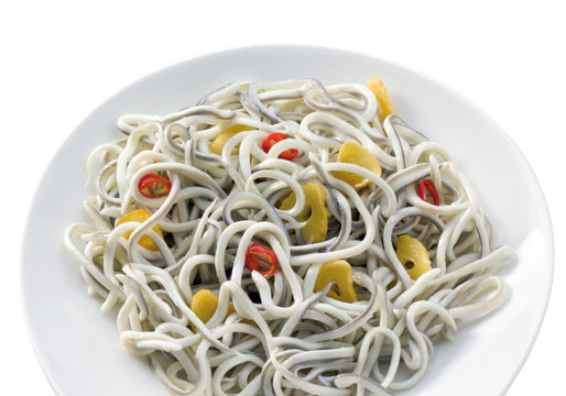 gulas con ajos y guindillas sobre fondo blanco. baby eels with garlic and chilli peppers on a white background.