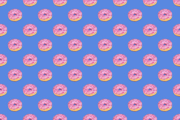 Fashionable seamless pattern of traditional doughnuts with lilac glaze on trendy classic blue...