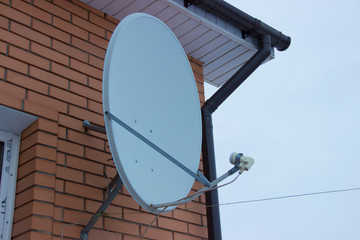 Satellite dish attached to the corner of the cottage