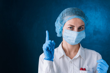 female doctor in mask and hat points a finger to the top