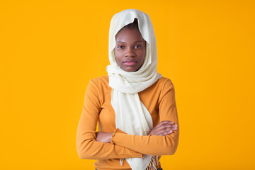 beautiful young african woman on yellow background with muslim shawl