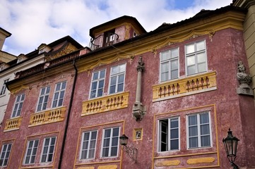 Fototapeta na wymiar Old bohemian building with yellow balconies and a red wall (Prague, Czech Republic, Europe)