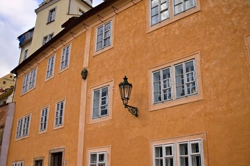Fototapeta na wymiar Isolate black street lantern hanging on an orange building wall (Prague, Czech Republic, Europe)