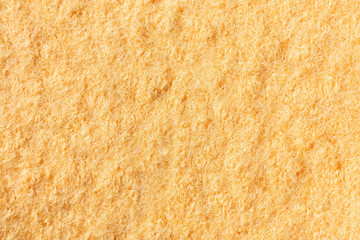Light yellow background of felted wool, close up.