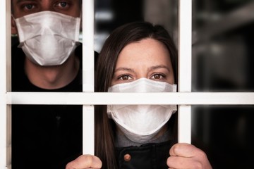 A woman in a mask , looking intently at the camera. Quarantine and isolation of patients with covid...