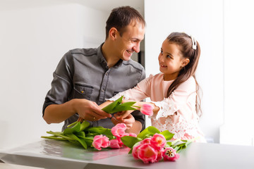 Father and daughter holding a bouquet of tulips
