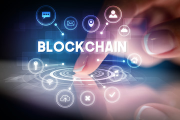 Finger touching tablet with web technology icons and BLOCKCHAIN inscription, web technology concept