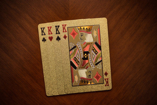 four king playing cards on wooden background, four playing cards of the same suit, playing cards one on one from above the king of diamonds, quads of kings, 4 gold kings