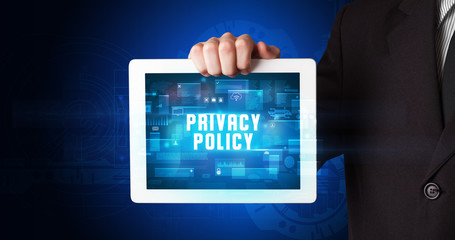 Young business person working on tablet and shows the digital sign: PRIVACY POLICY