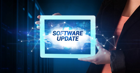 Young business person working on tablet and shows the inscription: SOFTWARE UPDATE