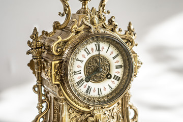 dial of vintage bronze clock, antique clock photo close up, old bronze clock in gilding, front of bronze fireplace clock, eight o'clock on the dial , 8 pm on the dial of the old watch