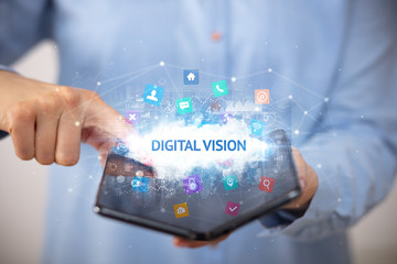 Businessman holding a foldable smartphone with DIGITAL VISION inscription, technology concept