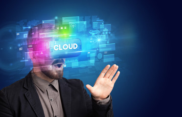 Businessman looking through Virtual Reality glasses with CLOUD inscription, innovative security concept