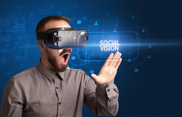 Businessman looking through Virtual Reality glasses with SOCIAL VISION inscription, social networking concept