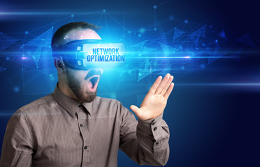 Businessman looking through Virtual Reality glasses with NETWORK OPTIMIZATION inscription, cyber security concept