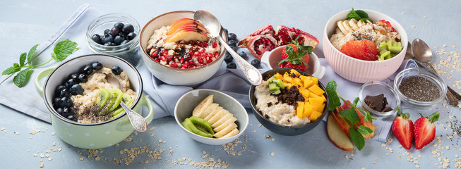 Bowls of oatmeal with berries and fruits  for healthy breakfast. Food with vitamins, minerals and antioxidants. Top view with copy space