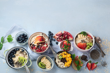 Bowls of oatmeal with berries and fruits  for healthy breakfast. Food with vitamins, minerals and antioxidants. Top view with copy space