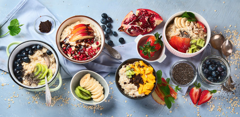 Bowls of oatmeal with berries and fruits  for healthy breakfast. Food with vitamins, minerals and antioxidants. Top view. Panorama, banner