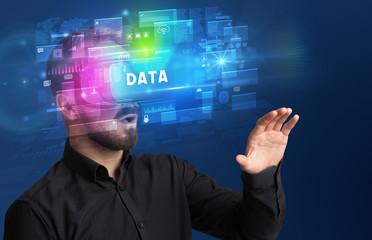 Businessman looking through Virtual Reality glasses with DATA inscription, innovative security concept
