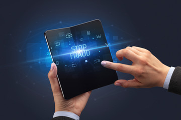 Businessman holding a foldable smartphone with STOP FRAUD inscription, cyber security concept