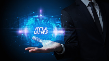 Man hand holding VIRTUAL MACHINE inscription, technology concept