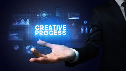 Hand of Businessman holding CREATIVE PROCESS inscription, business success concept