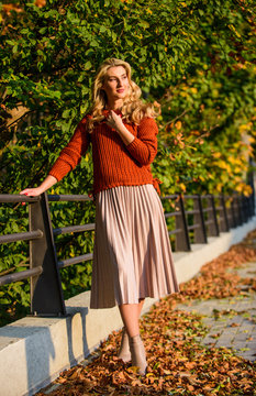 Autumn girl. girl walk in park. sunny day with fallen leaves. fall fashion season. female beauty. Femininity and tenderness. girl in corrugated skirt and sweater. Pleated trend. autumn woman outdoor