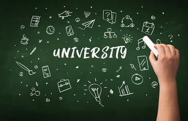 Hand drawing UNIVERSITY inscription with white chalk on blackboard, education concept