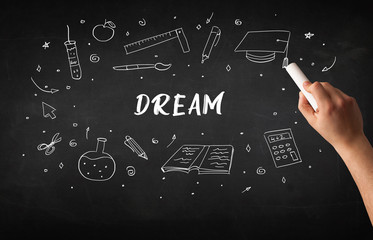 Hand drawing DREAM inscription with white chalk on blackboard, education concept