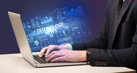 Businessman working on laptop with TECHNOLOGY NEWS inscription, cyber technology concept