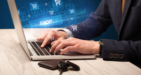 Businessman working on laptop with SHOP inscription, online shopping concept