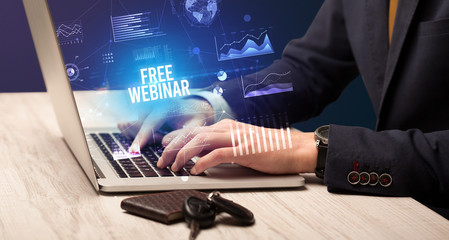 Businessman working on laptop with FREE WEBINAR inscription, new business concept