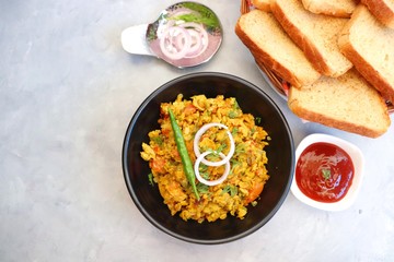 Indian Breakfast Dish - Parsi Akuri or Anda Bhurji or Indian spicy scrambled eggs served with toasted brown bread & ketchup. Famous Indian street food. Ingredients background with copy space.