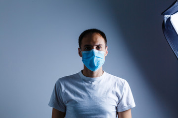 Strong man wearing mask to prevent flu virus and dust air pollution on white background