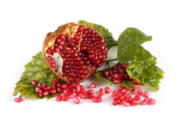 Pomegranate half and autumn leaves isolated on white